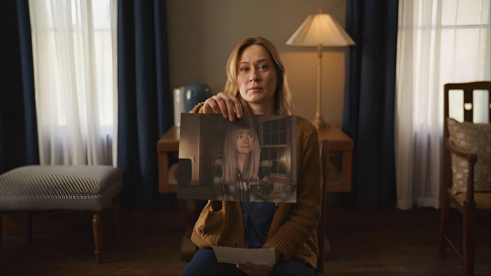 Camille Sullivan’s character holds a photograph of her missing sister, the focus of the film’s mystery. (Image via Instagram/@neonrated)